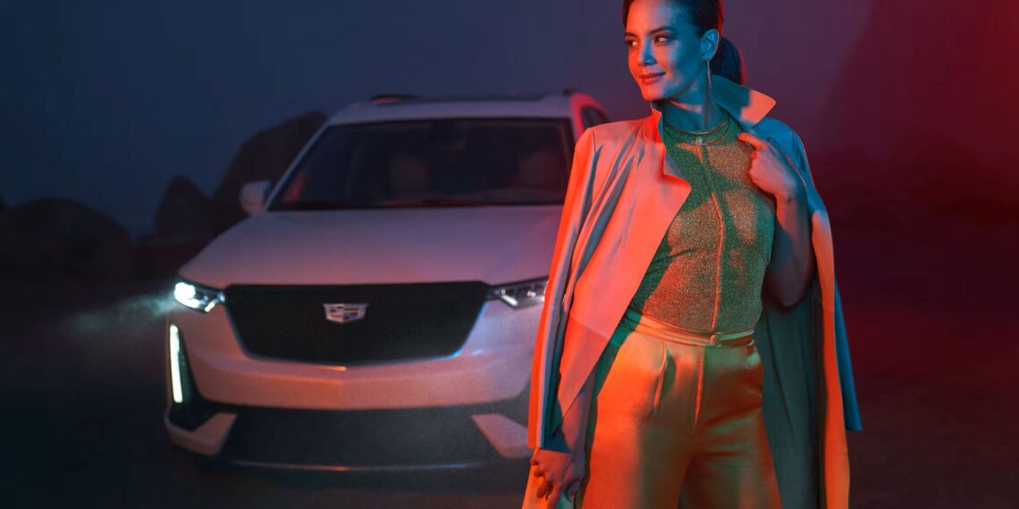2025 Cadillac XT6 behind a stylish woman at night