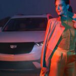2025 Cadillac XT6 behind a stylish woman at night