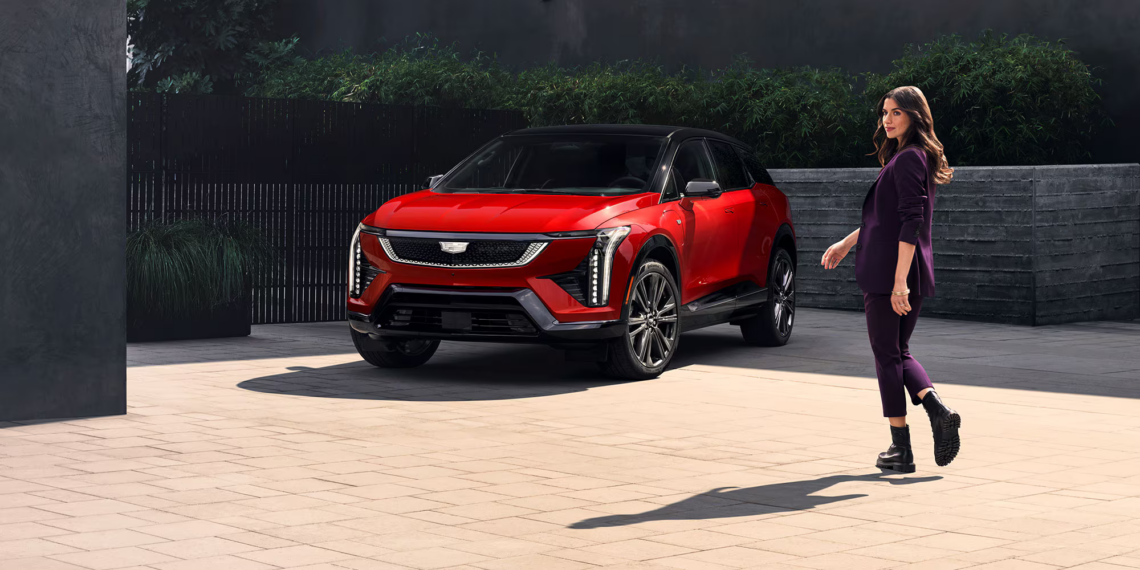 Radiant Red and Black 2026 Cadillac OPTIQ and a woman